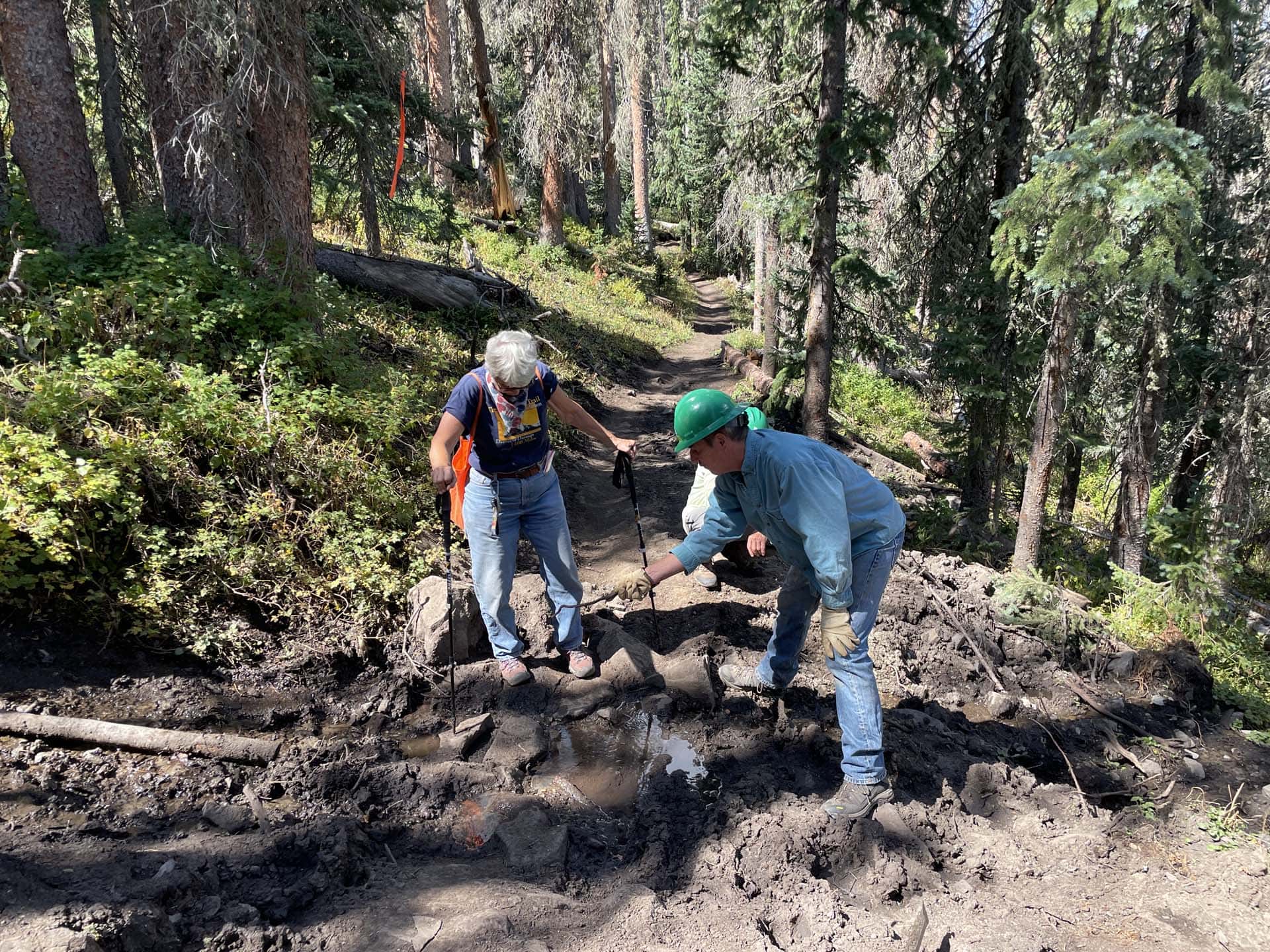 crew workers repair muddy section of trail