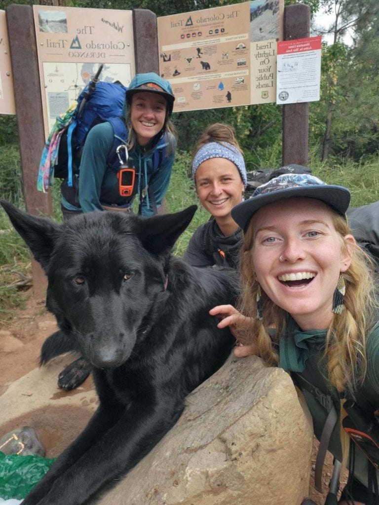 dog-group with dog group pose with black dog at durango colorado trail sign